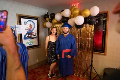 Qalin jabiyay oo xidhan koofiyad buluug ah iyo goon buluug ah ayaa la sawirtay naag ku labisan maro madow.